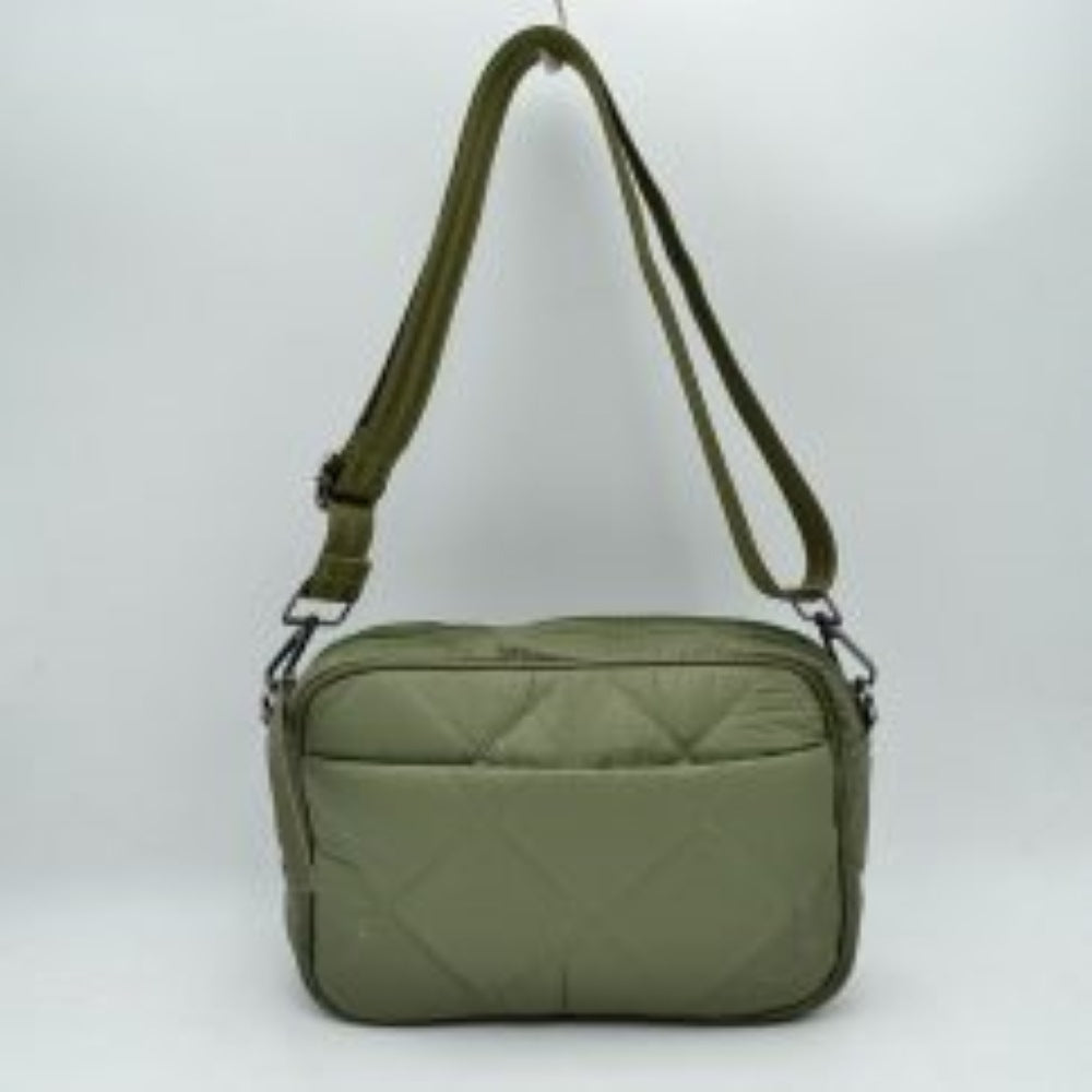 Olive This functional crossbody bag features a soft, lightweight puffer exterior with a classic quilted diamond pattern in a sleek dark grey tone, making it a practical choice for organized daily use. The front panel is detailed with a subtle open slip pocket accented by a long, flat fabric pull on the corner. Equipped with a secure top zipper closure to keep your main compartment essentials safe, the bag is finished with gunmetal-tone hardware and a long, adjustable webbing shoulder strap for a comfortable