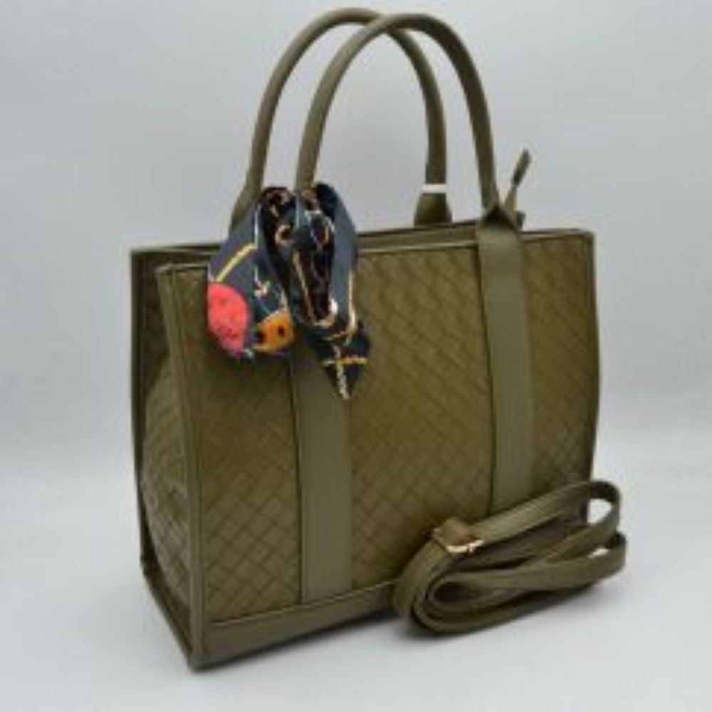 Olive This structural tote bag features an intricate woven textured pattern across its panels, delivering a sophisticated look suitable for everyday use. It is designed with dual rounded top handles extending down the front and back as solid vertical bands, alongside a secondary adjustable strap visible behind for alternative carrying options. The spacious main storage compartment secures with a top zipper closure