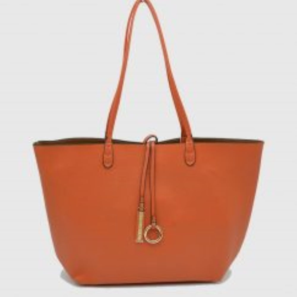 Orange-Brown This classic tote bag features a smooth exterior finish with a timeless trapeze silhouette, offering an elegant look for everyday use. Designed with an open top for quick access, the spacious main compartment provides ample storage space for daily essentials. Dual slim shoulder handles are securely stitched to the upper panels, while a decorative central drawstring tie accents the front, complete with a metallic ring and matching tab accent for a polished touch.