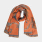 A soft scarf featuring an elegant floral print with a bordered edge and fringe finish. Lightweight yet cozy, this versatile accessory brings warmth and a touch of sophistication to casual and dressy outfits.