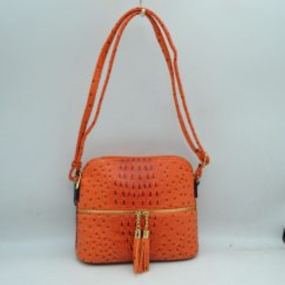 Orange This vibrant crossbody bag features a structured dome silhouette with a bold, ostrich-embossed texture in a striking neon orange hue, making it a standout accessory for everyday style. The front is detailed w/ an horizontal zipper compartment equipped w/ dual gold-tone zipper pulls finished with matching long tassel accents for a playful touch. Secured by a main top zipper closure to keep your essentials safe, it is completed w/ a long, adjustable shoulder strap for a comfortable, hands-free carry.