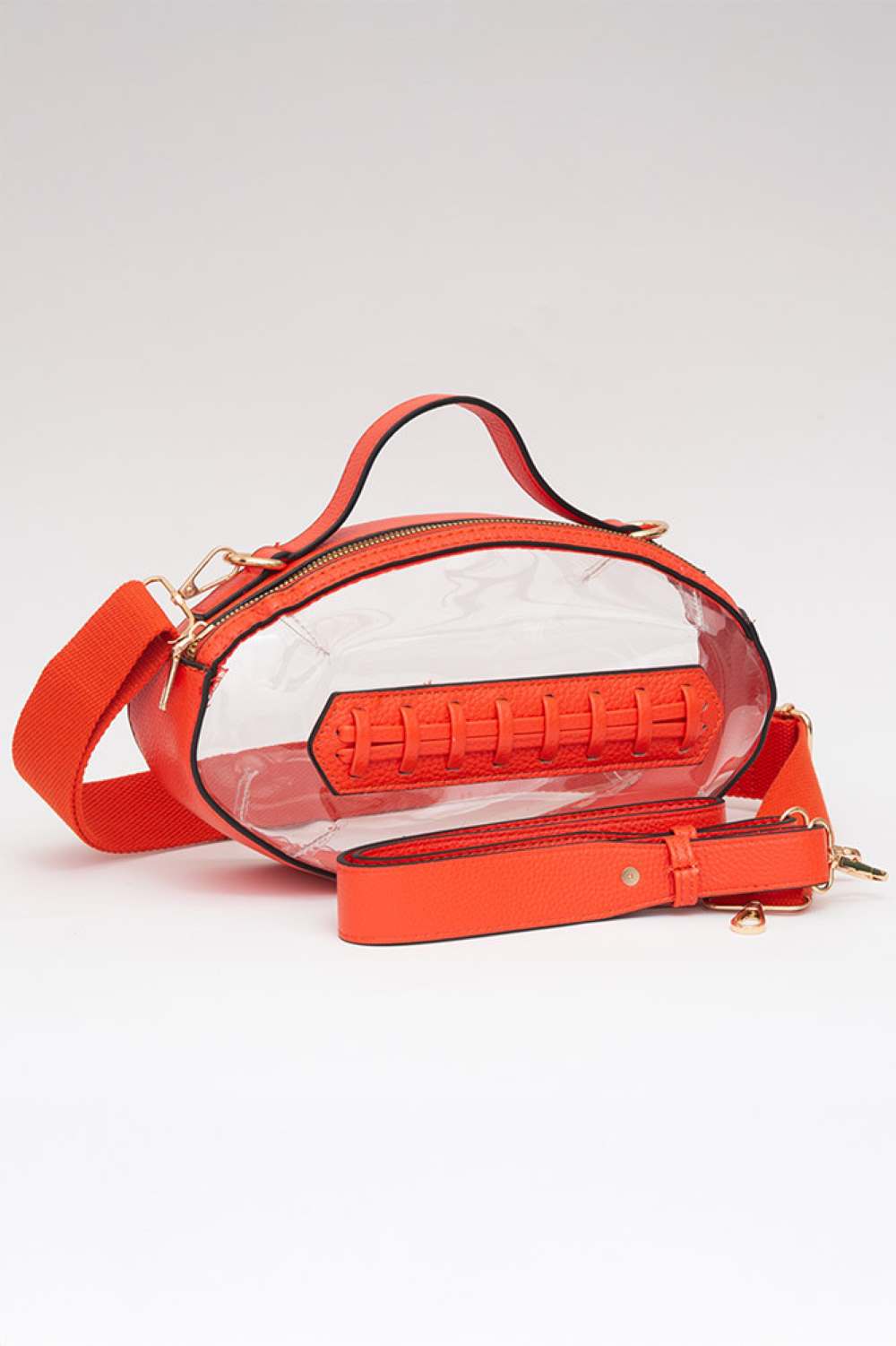 Orange Carry your essentials in style with this unique football-shaped transparent crossbody bag. Perfect for stadium events, concerts, and outdoor gatherings, the clear PVC design lets you see everything inside while meeting venue security requirements. Measuring 11" x 6" x 4", it offers practical storage without bulk. The adjustable crossbody strap keeps your hands free, making it ideal for busy days out. Durable 100% PVC construction ensures long-lasting wear through countless adventures.