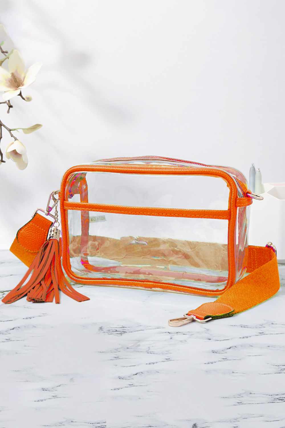 Orange Clear Clear PU Cross Body Camera Bag offers a sleek, transparent design crafted from durable polyurethane, providing both style and protection for your camera gear. Its crossbody strap ensures comfortable, hands-free carrying, while the clear material allows quick visibility of contents for easy access. Ideal for photographers seeking a practical yet modern solution to transport and safeguard their equipment.