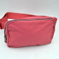Peach This minimalist bag features a smooth, clean design ideal for versatile everyday use. The main storage compartment is secured by a curved top zipper with dual pulls for easy access to essentials. A wide, adjustable strap extends from the sides, complete with a matching slider to easily customize the fit for comfortable carrying.