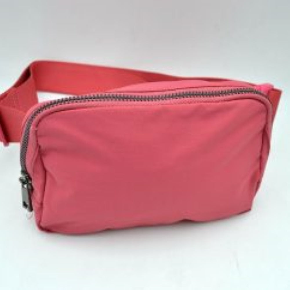 Peach This minimalist bag features a smooth, clean design ideal for versatile everyday use. The main storage compartment is secured by a curved top zipper with dual pulls for easy access to essentials. A wide, adjustable strap extends from the sides, complete with a matching slider to easily customize the fit for comfortable carrying.
