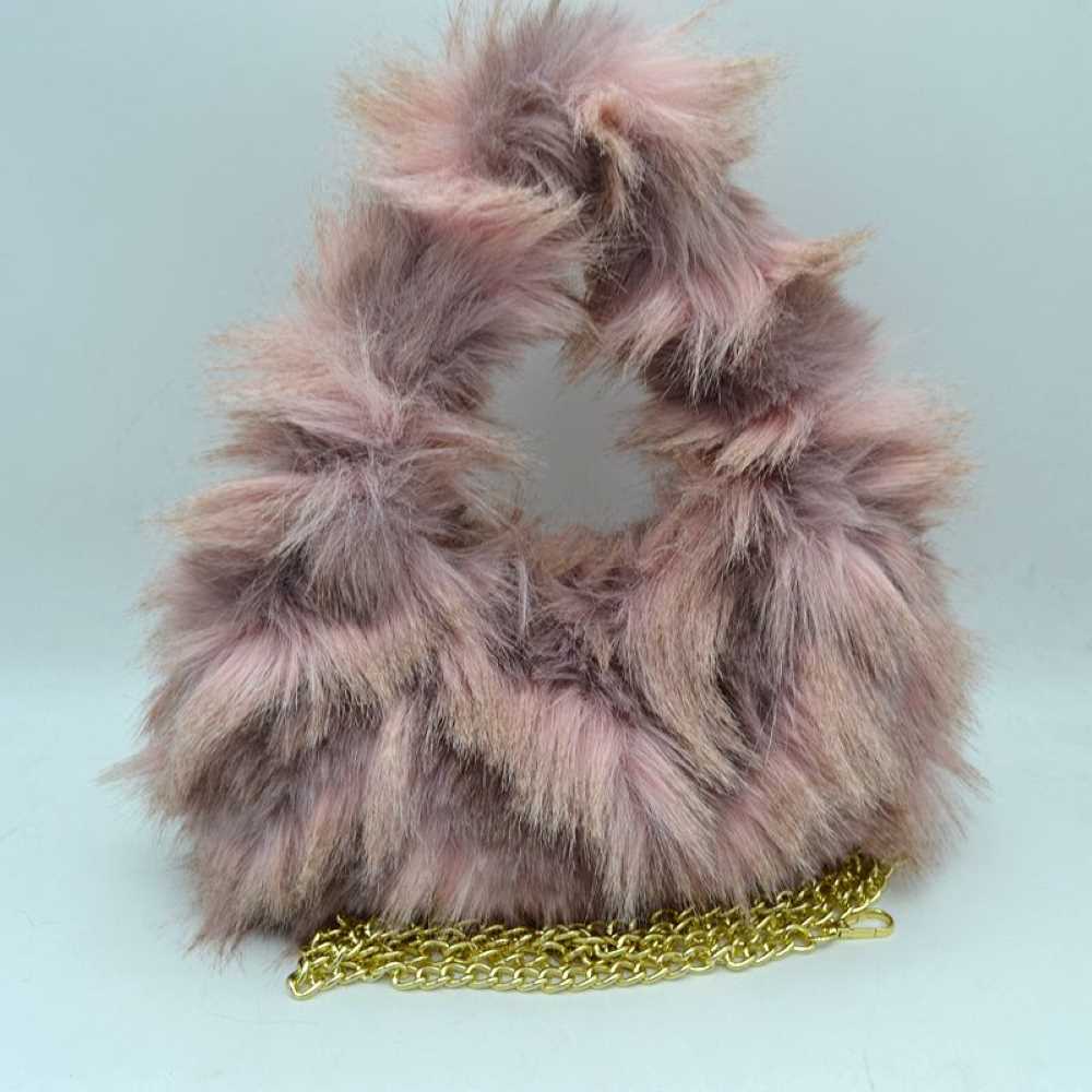Pink This distinctive everyday handbag showcases a statement-making, long-pile shaggy plush exterior that adds unique dimension and tactile texture to your accessory collection. Designed with a soft, rounded triangular silhouette, it features a built-in top cutout handle for convenient hand carrying, alongside a separate metallic chain strap for versatile alternative styling. The central top opening provides straightforward access to the main storage compartment