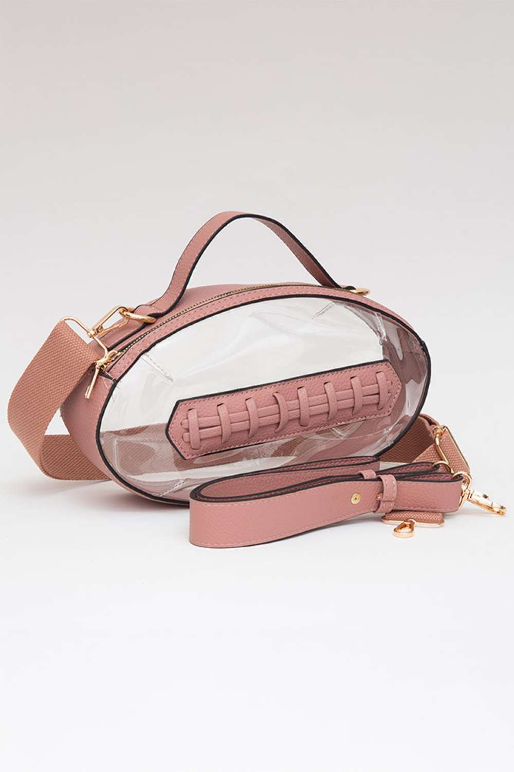 Pink Carry your essentials in style with this unique football-shaped transparent crossbody bag. Perfect for stadium events, concerts, and outdoor gatherings, the clear PVC design lets you see everything inside while meeting venue security requirements. Measuring 11" x 6" x 4", it offers practical storage without bulk. The adjustable crossbody strap keeps your hands free, making it ideal for busy days out. Durable 100% PVC construction ensures long-lasting wear through countless adventures.