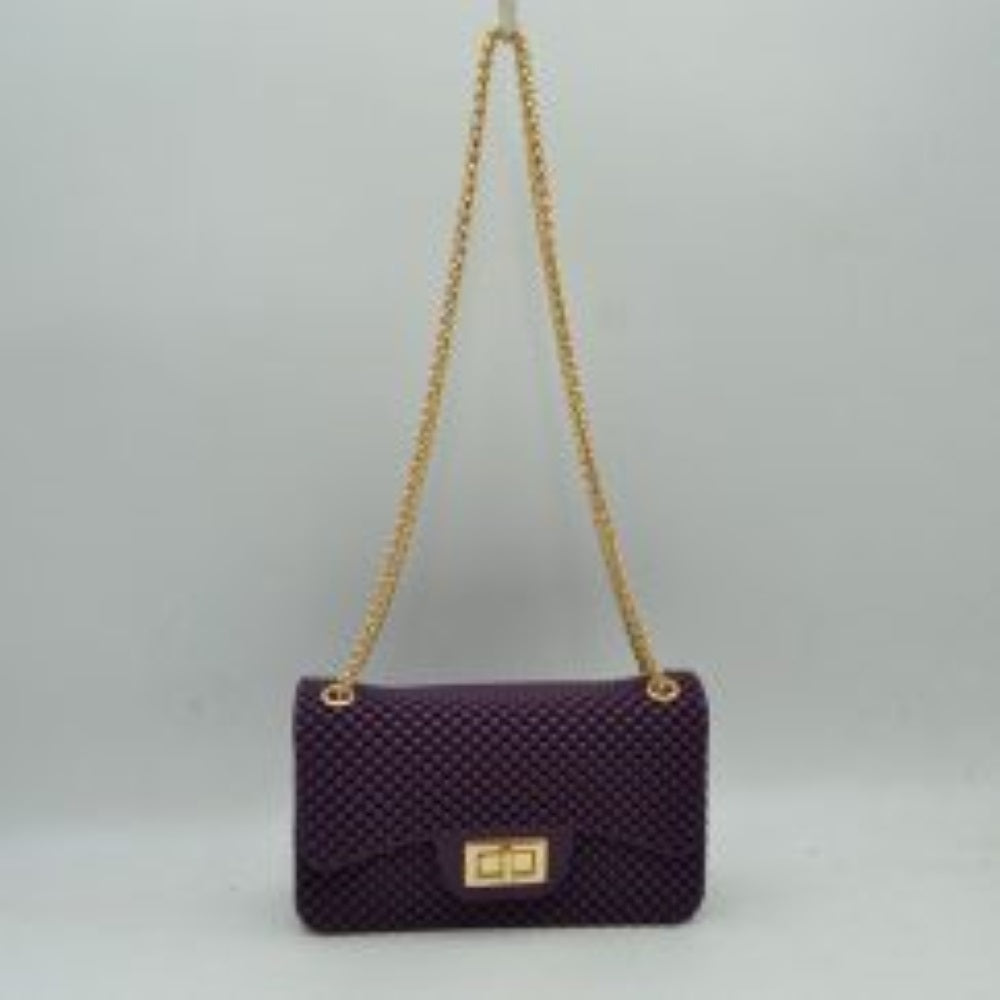 Purple This rectangular flap bag showcases a distinctive all-over bumpy textured design that adds unique tactile interest, making it a stylish choice for everyday use. The main storage compartment is safely secured by a front flap featuring a metallic twist-lock closure. Designed for easy carrying, the bag incorporates a long metallic chain shoulder strap fed through top eyelets, allowing it to rest comfortably on the shoulder throughout the day.