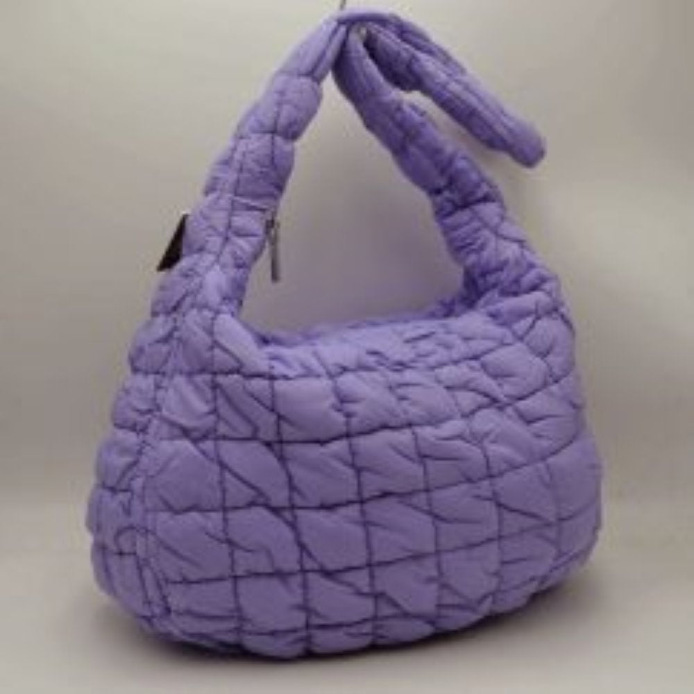 Purple This trendy shoulder bag features a soft, lightweight puffer exterior with a distinct square quilted pattern in a vibrant lavender purple hue, making it a stylish choice for everyday casual wear. Designed with a slouchy, crescent-shaped hobo silhouette, it offers a spacious main compartment secured by a streamlined top zipper closure to keep your essentials safe. The bag is completed with an integrated, wide padded shoulder strap that ensures a comfortable carry