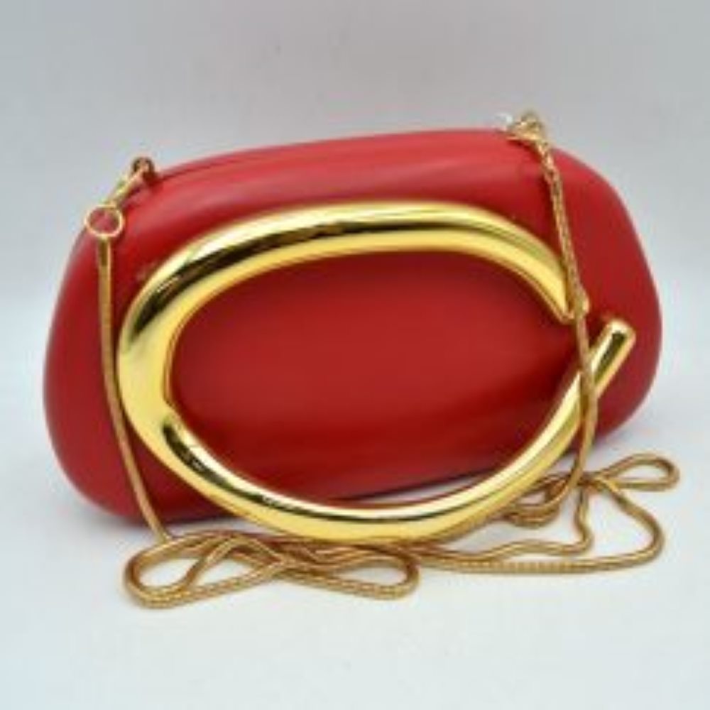 Red This structured, hard shell clutch bag functions as an elegant accessory for everyday use or special occasions, featuring a smooth matte surface. A large, prominent metallic ring handle anchors the front design, offering a secure hand-held grip. For alternative carrying styles, the bag is equipped with a detachable metallic snake chain strap that secures to the top corners with lobster claw clasps, providing functional storage in a compact, rigid silhouette.