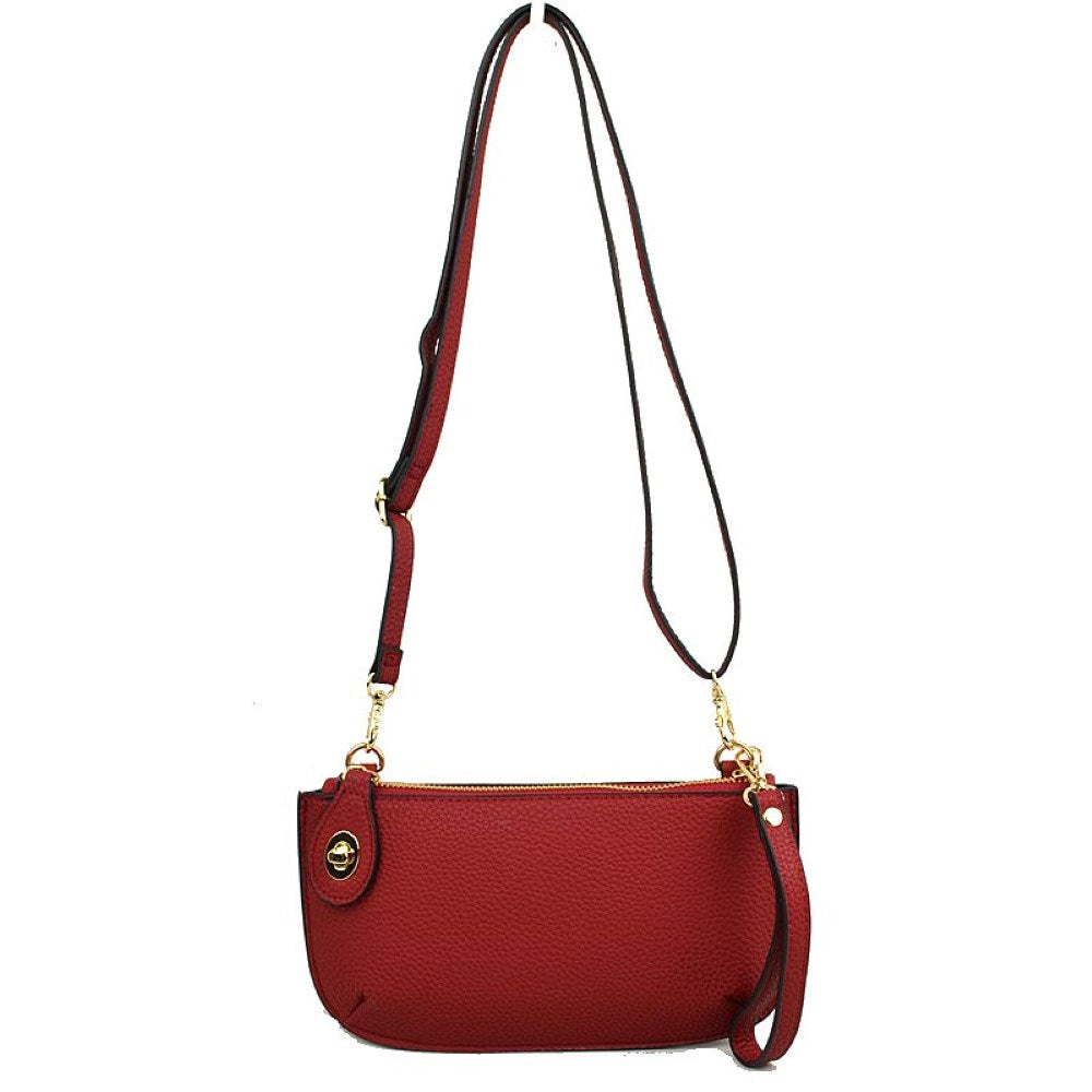 Red This versatile everyday bag features a compact pebbled textured body with a slightly curved base silhouette. Designed for organized daily or evening use, the main storage compartment is secured by a top zipper closure and accented with a small decorative metallic turn-lock detail on the side panel. It offers multiple carrying options, equipped with a long, adjustable crossbody shoulder strap and a shorter matching wristlet loop
