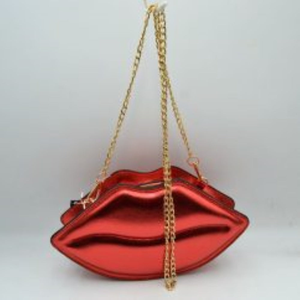 Red This novelty crossbody bag features a unique lip-shaped design with a high-shine metallic finish that adds a playful statement to any ensemble. Designed for everyday use or special occasions, it features a secure top zipper closure to keep small essentials protected while on the go. Equipped with a long, metallic chain-link shoulder strap that attaches via sturdy clasps, this eye-catching accessory offers convenient and stylish hands-free carrying.