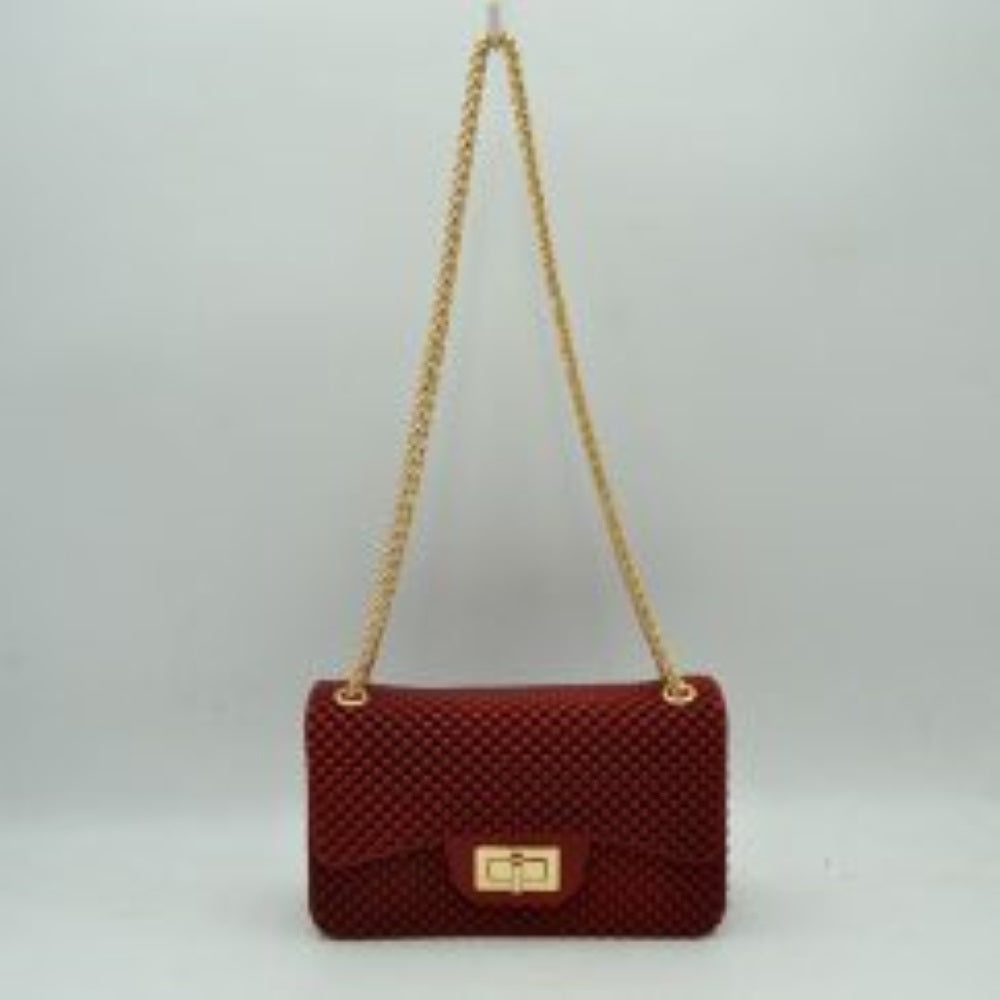 Red This rectangular flap bag showcases a distinctive all-over bumpy textured design that adds unique tactile interest, making it a stylish choice for everyday use. The main storage compartment is safely secured by a front flap featuring a metallic twist-lock closure. Designed for easy carrying, the bag incorporates a long metallic chain shoulder strap fed through top eyelets, allowing it to rest comfortably on the shoulder throughout the day.