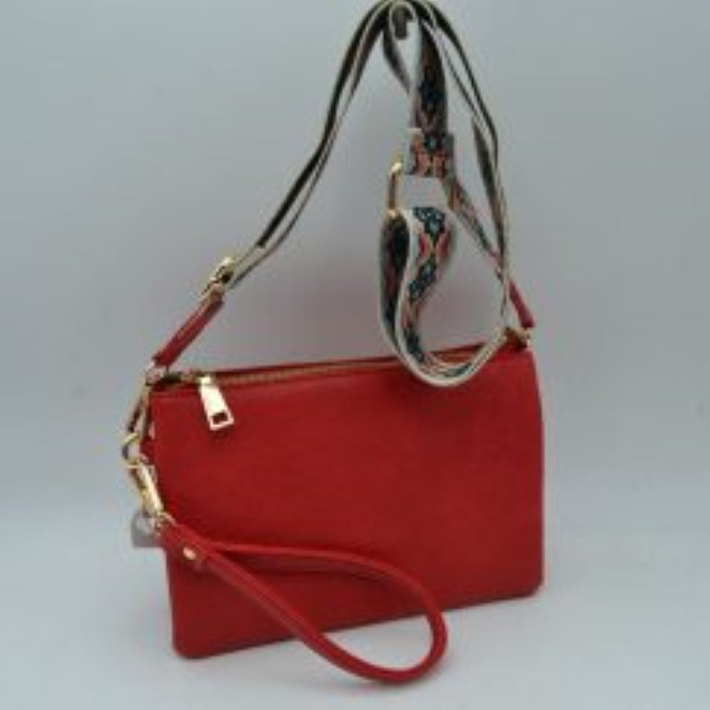 Red This versatile clutch is designed for seamless everyday transition and features multiple carrying options to suit your style. It is equipped with secure top zipper compartments to keep your daily essentials safely organized and within reach. For carrying flexibility, the bag comes with both a matching wristlet loop and a wide, adjustable shoulder strap decorated with a detailed geometric woven pattern, both attaching easily via sturdy metallic clasps.