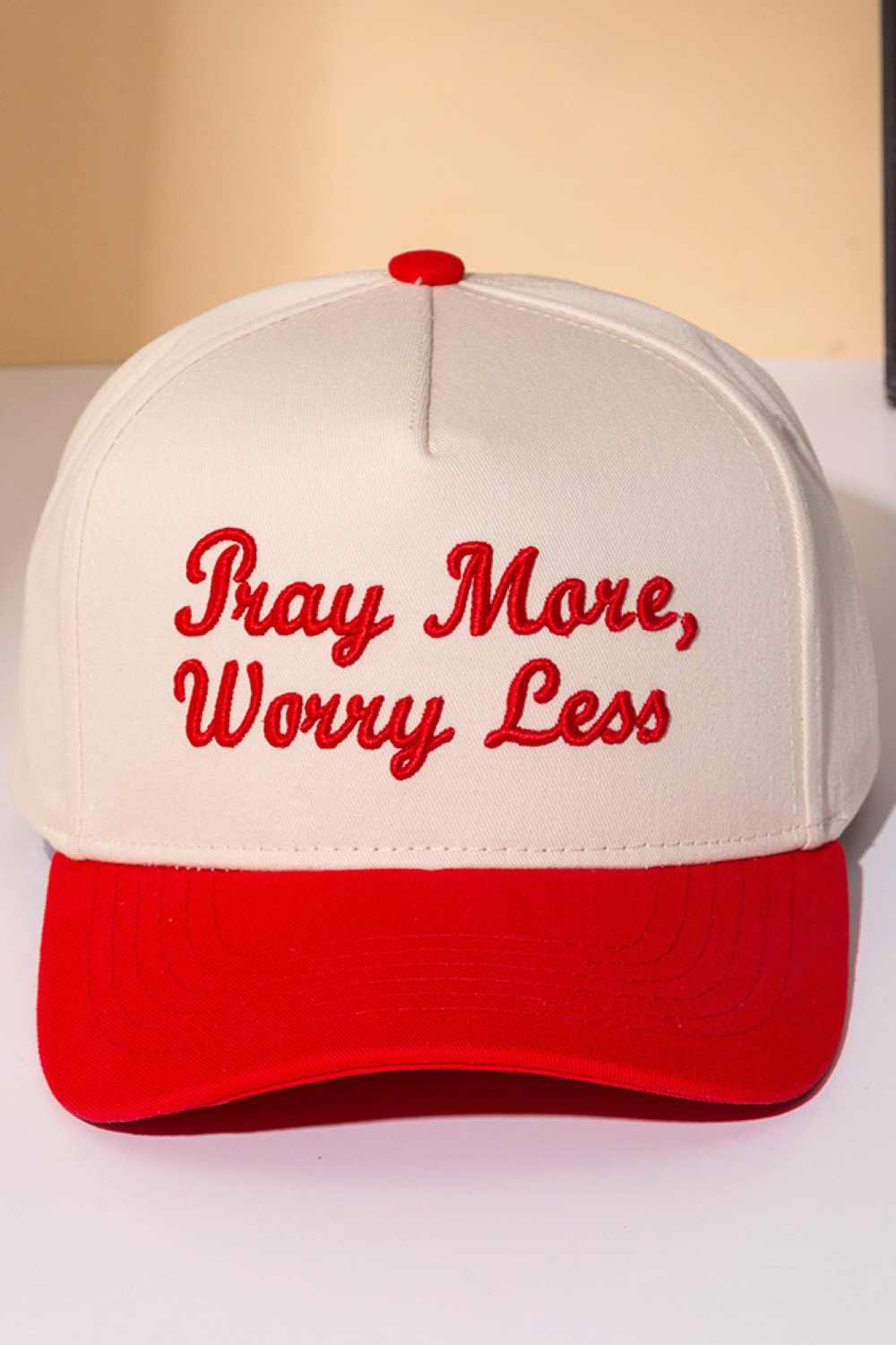 Red Stay grounded with this classic two-tone trucker cap featuring an embroidered "PRAY MORE, WORRY LESS" message. Crafted from 100% cotton for breathability and comfort, it's designed to keep you cool whether you're on the road or relaxing at home. The adjustable snapback ensures a perfect fit for everyone, while the structured six-panel design offers timeless style. A meaningful reminder to embrace peace and let go of stress, one wear at a time.
