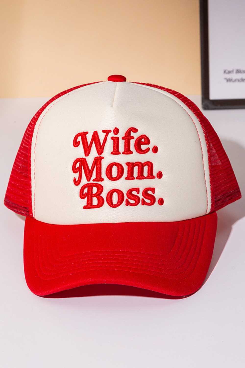 Red Perfect for the multitasking woman who does it all. This trucker cap features bold "WIFE MOM BOSS" lettering on a structured foam front with breathable mesh back paneling. The snapback closure ensures a comfortable, adjustable fit for any head size. Made from 100% polyester for durability and easy care. Whether you're heading to work, running errands, or just making a statement, this cap celebrates your hustle with style and attitude.