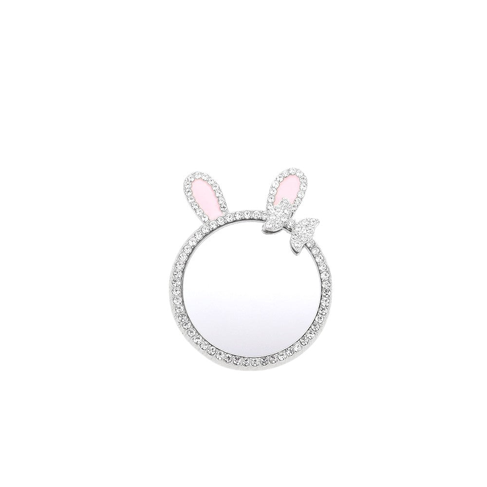 Rhodium Rhinestone Bunny Bow Mirror Adhesive Phone Grip and Stand is the perfect accessory for your phone. The rhinestone embellishments add a touch of glamour, while the mirror feature is convenient for on-the-go touch-ups. The adhesive backing provides a secure grip, making it a versatile and functional accessory. 