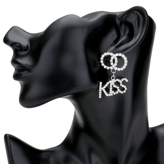 Rhodium KISS Rhinestone Embellished Message Dangle Earrings are the perfect accessory to add a touch of glamour to any outfit. The delicate dangle design adds movement and sparkle to your look, making you stand out from the crowd. Own these stunning earrings and shine like a star.