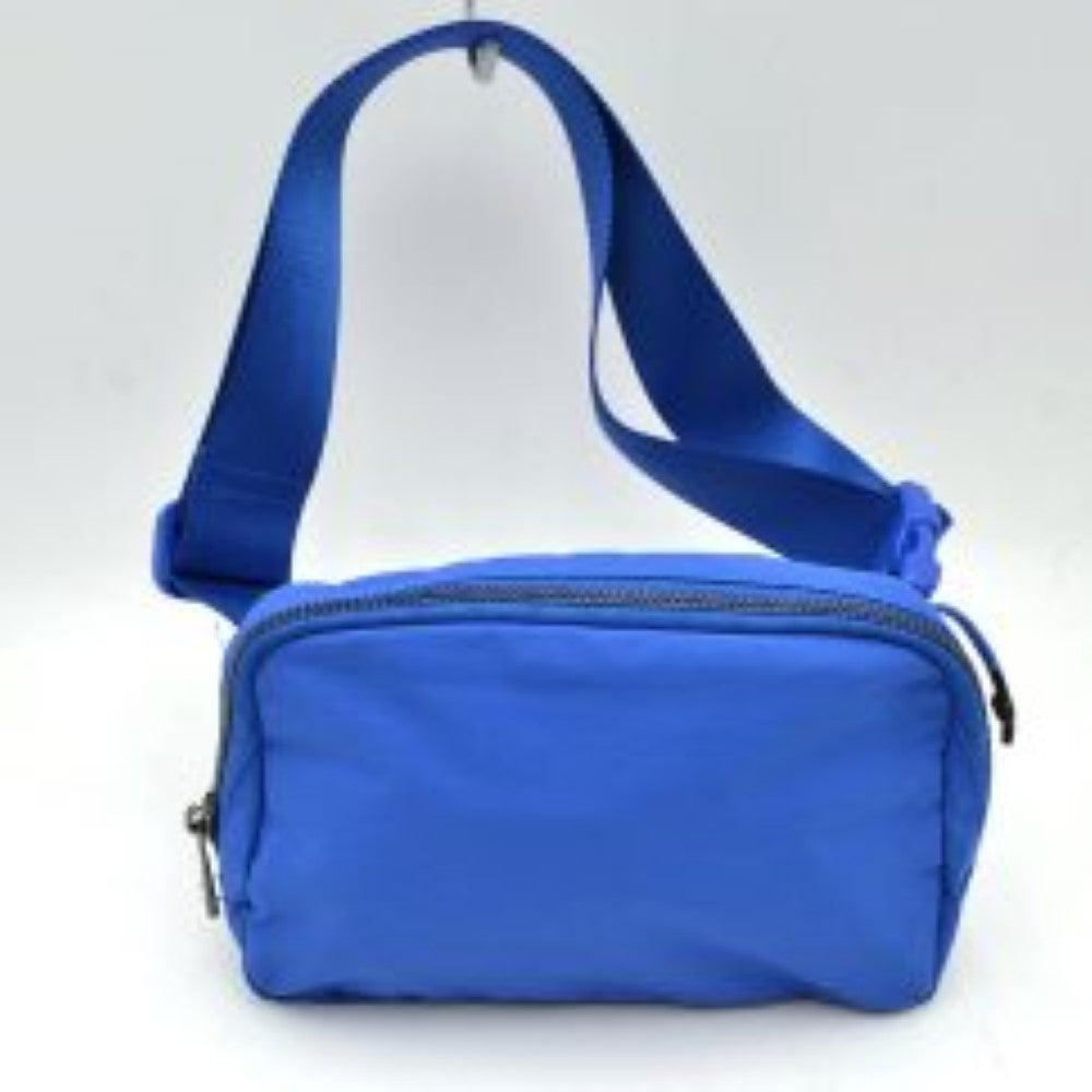 Royal blue This minimalist bag features a smooth, clean design ideal for versatile everyday use. The main storage compartment is secured by a curved top zipper with dual pulls for easy access to essentials. A wide, adjustable strap extends from the sides, complete with a matching slider to easily customize the fit for comfortable carrying.