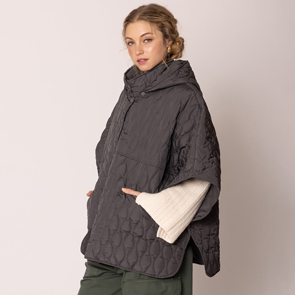 Charcoal Stylish quilted cape jacket featuring a relaxed silhouette, button-up front, and attached hood for added comfort. Perfect for layering during cooler seasons, this versatile outerwear piece combines warmth with a modern, minimalistic design for effortless everyday style.