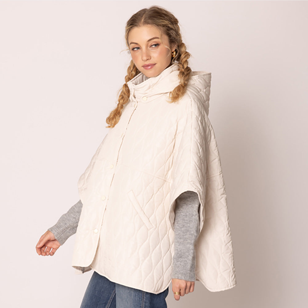 Ivory Stylish quilted cape jacket featuring a relaxed silhouette, button-up front, and attached hood for added comfort. Perfect for layering during cooler seasons, this versatile outerwear piece combines warmth with a modern, minimalistic design for effortless everyday style.
