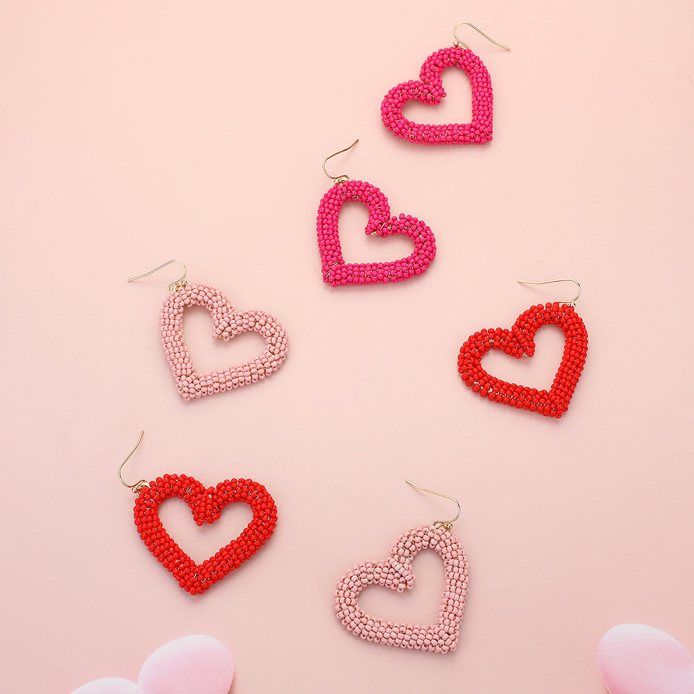 Seed Beaded Open Heart Dangle Earrings are handcrafted with delicate beads, forming an open heart that dangles elegantly. The intricate design adds a touch of romance to any outfit. These earrings are versatile and can be worn for any occasion, perfect for any fashion-forward individual. 