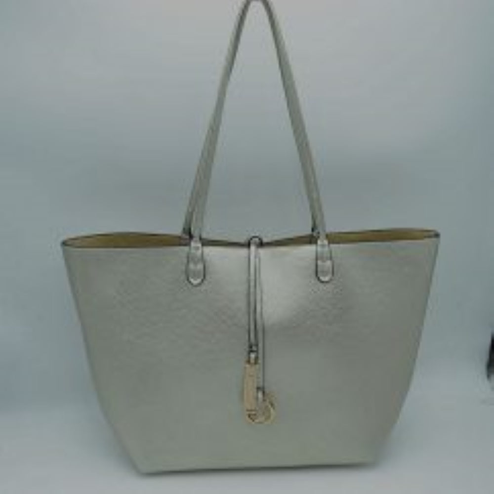 Silver-Gold This classic tote bag features a smooth exterior finish with a timeless trapeze silhouette, offering an elegant look for everyday use. Designed with an open top for quick access, the spacious main compartment provides ample storage space for daily essentials. Dual slim shoulder handles are securely stitched to the upper panels, while a decorative central drawstring tie accents the front, complete with a metallic ring and matching tab accent for a polished touch.