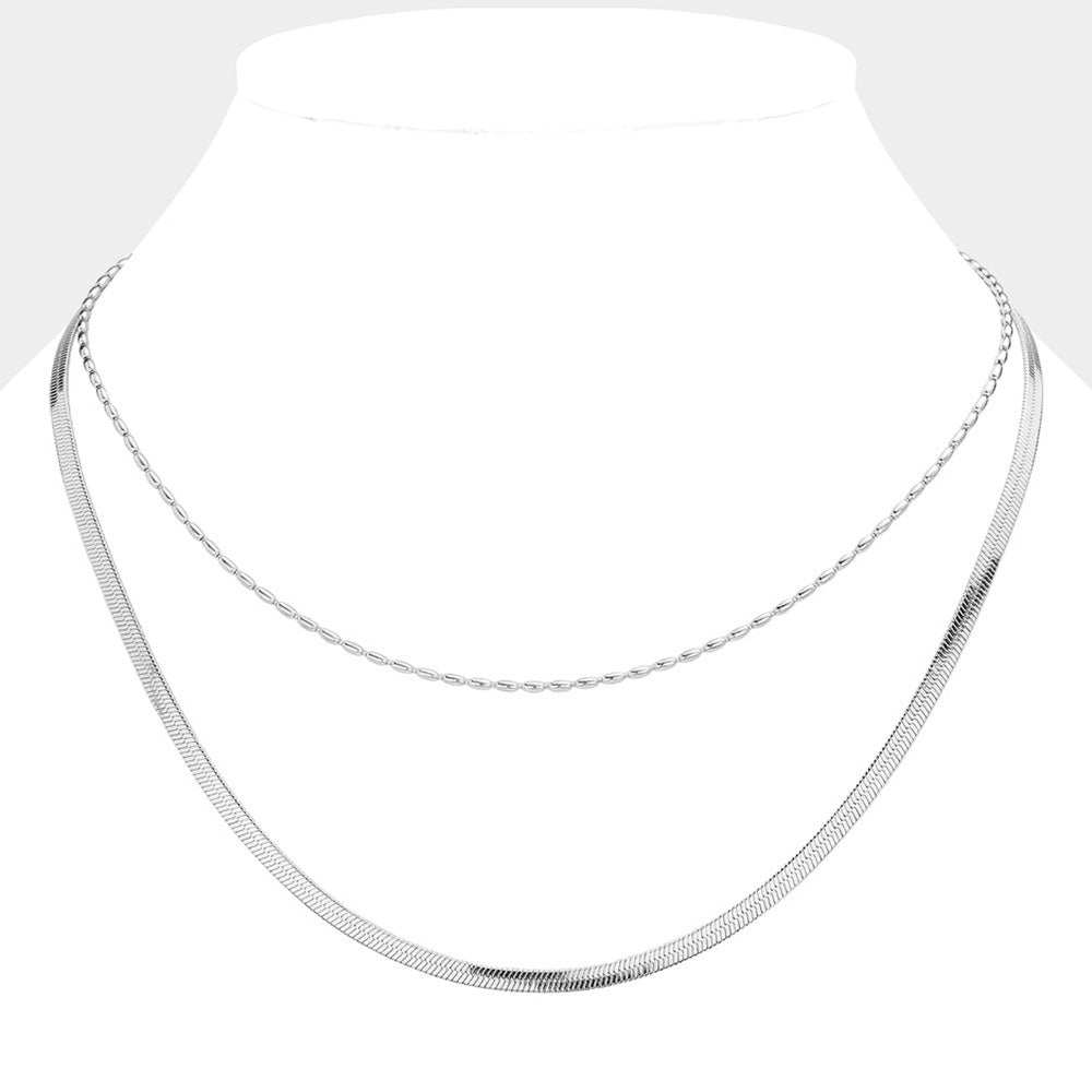 Silver Stainless Steel Herringbone Chain Layered Necklace offers a sleek and stylish addition to any outfit. Crafted from high-quality stainless steel, this necklace is durable and resistant to tarnishing. Its herringbone chain design adds a unique touch, making it a versatile piece for any occasion. Elevate your look with this modern and sophisticated accessory.