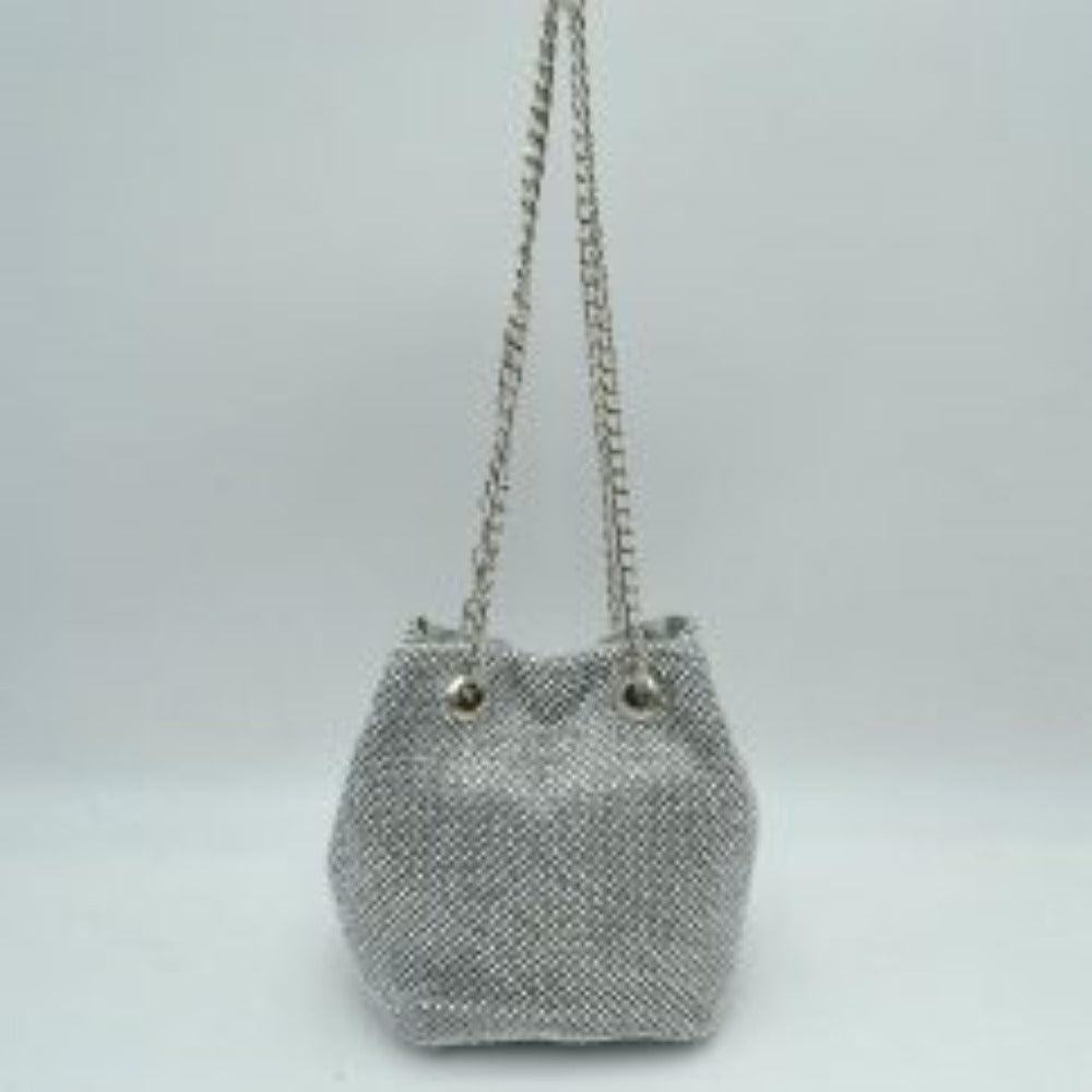 Silver This bucket bag features a shimmering, textured mesh exterior ideal for everyday use and evening transitions. The main storage compartment is designed with a gathered top entry that opens up for effortless access to your items. Two matching metallic link chain straps pull through circular metal grommets on the front and back, serving as a functional drawstring mechanism while doubling as a comfortable shoulder carry style.