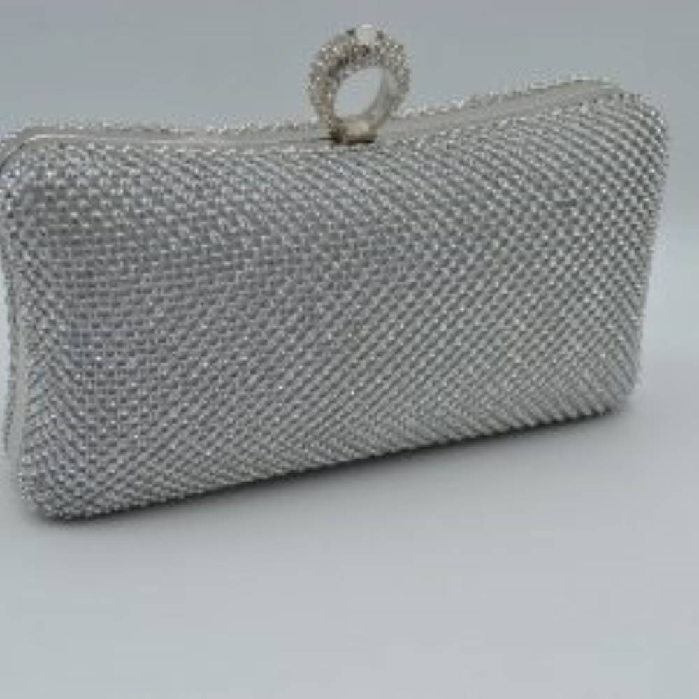 Silver This hard-shell box clutch features a curved rectangular profile entirely covered in neat rows of small, shimmering circular embellishments for an elegant accent to everyday ensembles. A prominent, textured ring-style clasp sits centered at the top, serving as both a functional closure mechanism to access the interior storage compartment and an integrated finger-loop handle element for secure hand-held carrying.