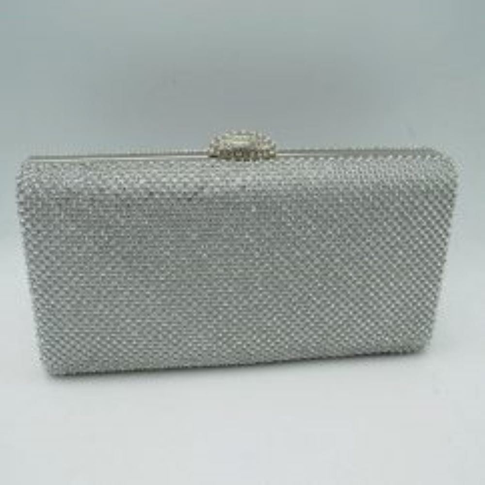 Silver This sleek, hard-shell box clutch features a uniformly patterned exterior covered in small, shimmering circular studs that add a refined texture for everyday use and social outings. A smooth metallic frame outlines the top opening, accented by a decorative, jewel-encrusted dome clasp centered along the rim. This structured clasp acts as a functional lift-lock mechanism to open the bag, providing quick access to a compact main storage compartment designed to securely hold essential personal belongings