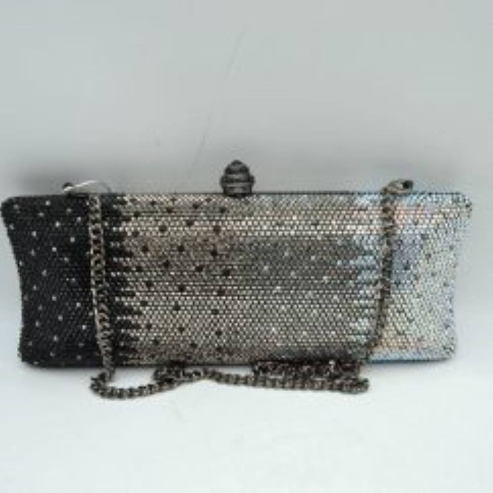 Silver-multi This structured clutch bag features an elongated silhouette with subtly flared edges, completely covered in fine, glittering micro-embellishments that create a shimmering, textured surface suitable for elegant everyday use. The central storage compartment is securely accessed via a hard-frame opening with an ornamental, rounded top clasp. A long, slender metallic curb chain strap is permanently attached to the top loops