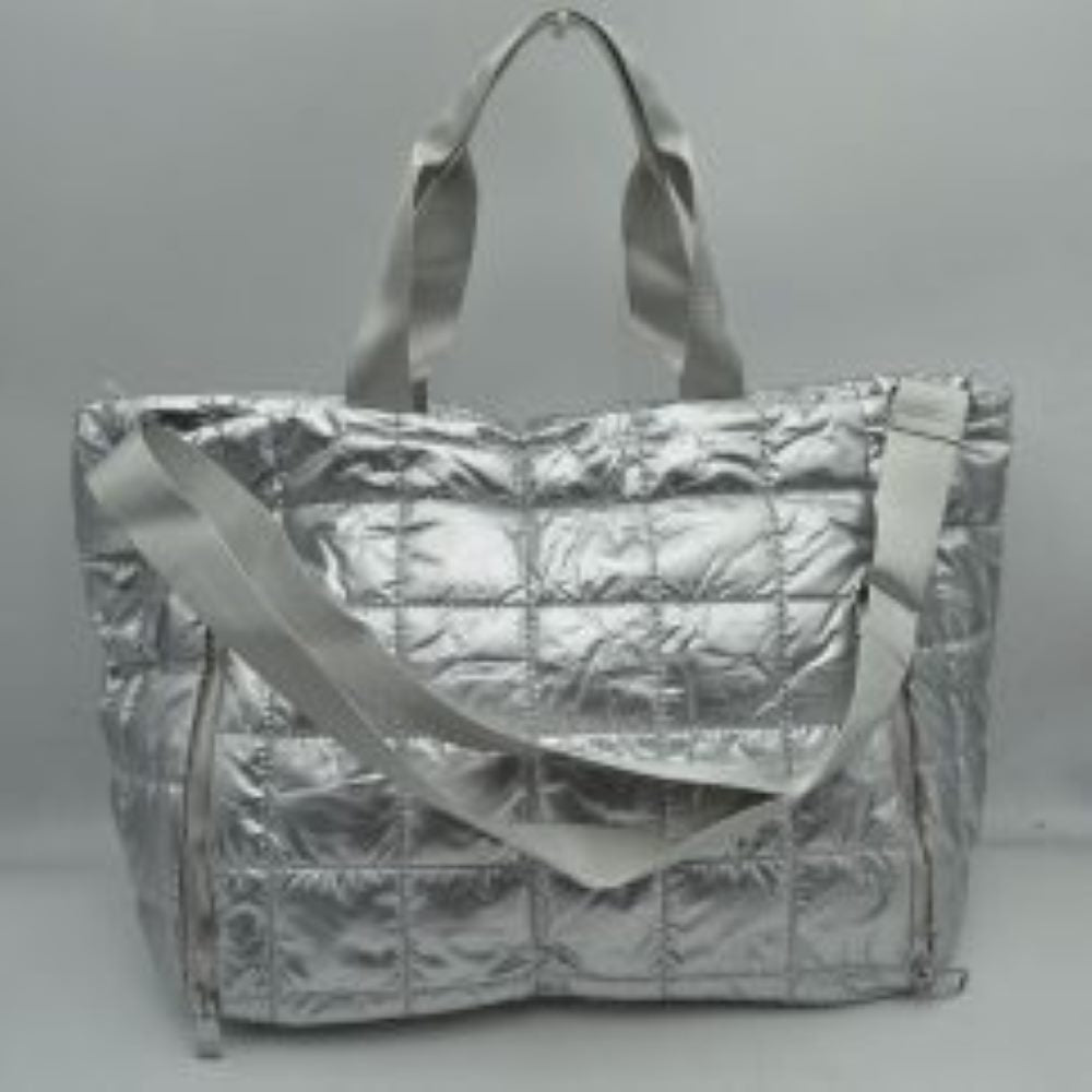 Silver Simplify your travel routine with this highly functional, lightweight grid-quilted puffer duffel bag, perfectly proportioned for overnight stays, weekend road trips, or gym days. Featuring a contemporary square quilted design, this soft-structured bag brings an athletic yet polished aesthetic to your transit style. The exterior features two prominent vertical zippered pockets on the lower front corners, keeping your passport, keys, or phone easily accessible while on the move.