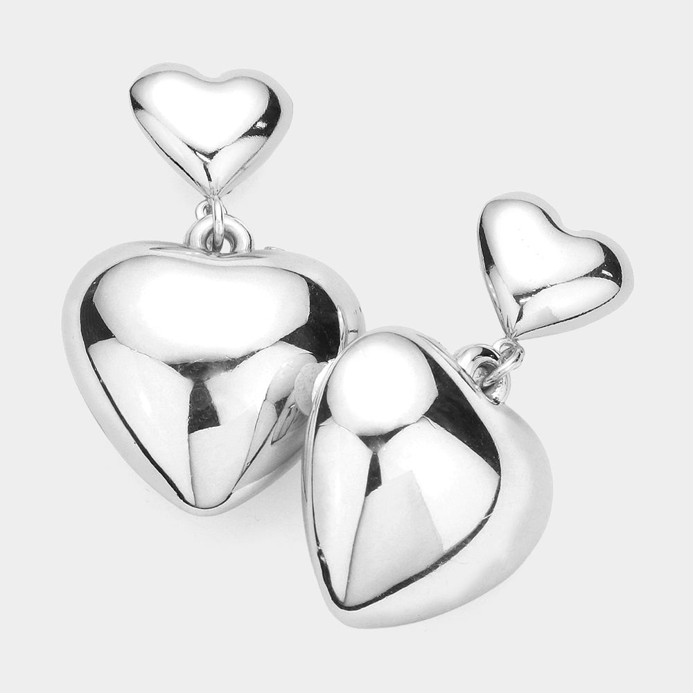 Silver Dipped Metal Heart Dangle Earrings feature a delicate design that will add a touch of sophistication to any outfit. The silver dipping process ensures a durable and long-lasting shine, while the heart dangle adds a subtle touch of romance. Elevate your style with these timeless earrings.