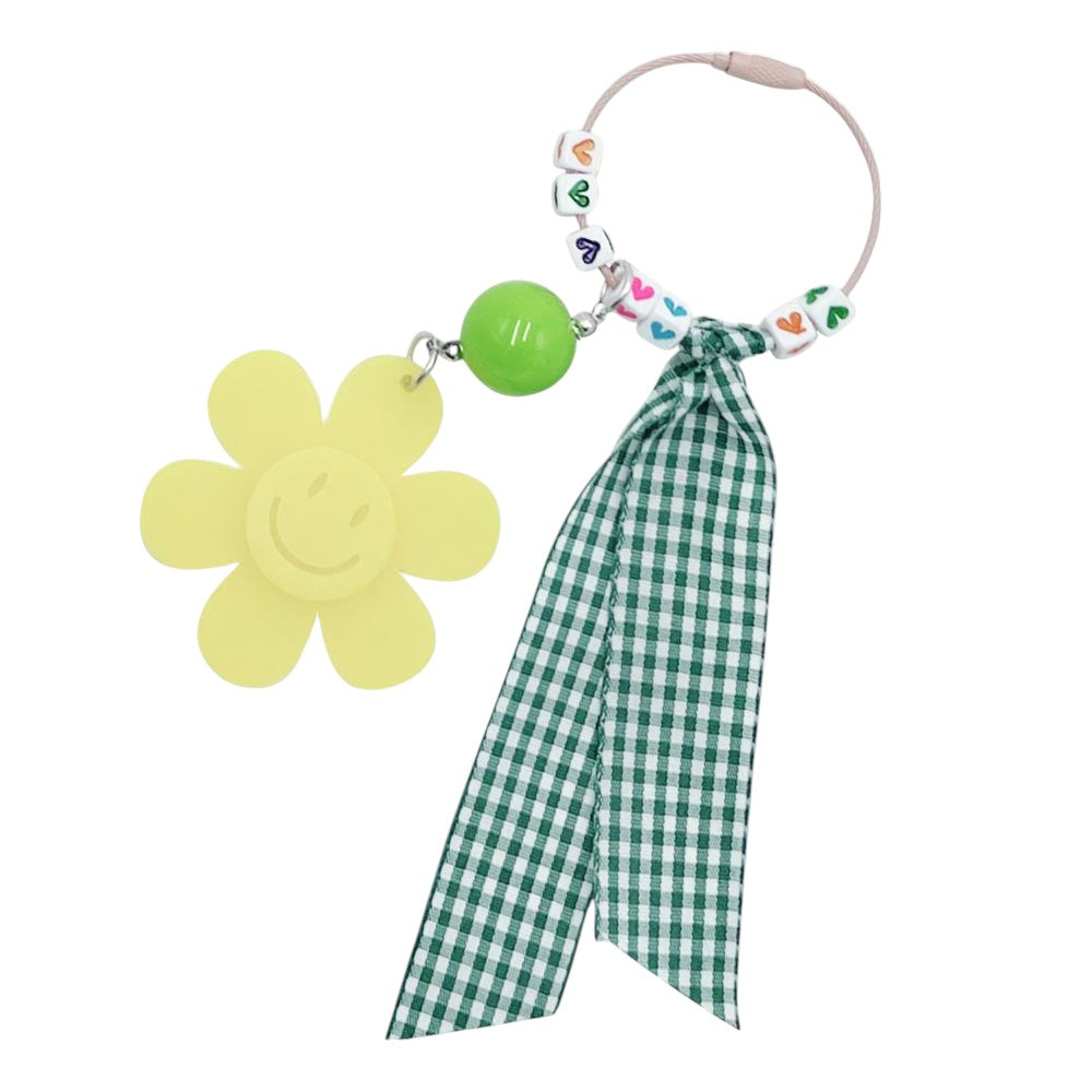 yellow Smile Flower Heart Gingham Ribbon Bag Charm / Keychain features a delicate gingham ribbon and a smile flower heart design. Add a touch of whimsy to your bag or keys with this delightful accessory. Made with high-quality materials, this charm is a perfect addition to any fashion-forward individual's collection. 