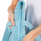 Blue Solid Crochet Straw Tote Bag is perfect for a day at the beach. Made from durable straw material, it features a spacious interior and sturdy handles for carrying all your essentials. Stay stylish and organized with this must-have accessory.