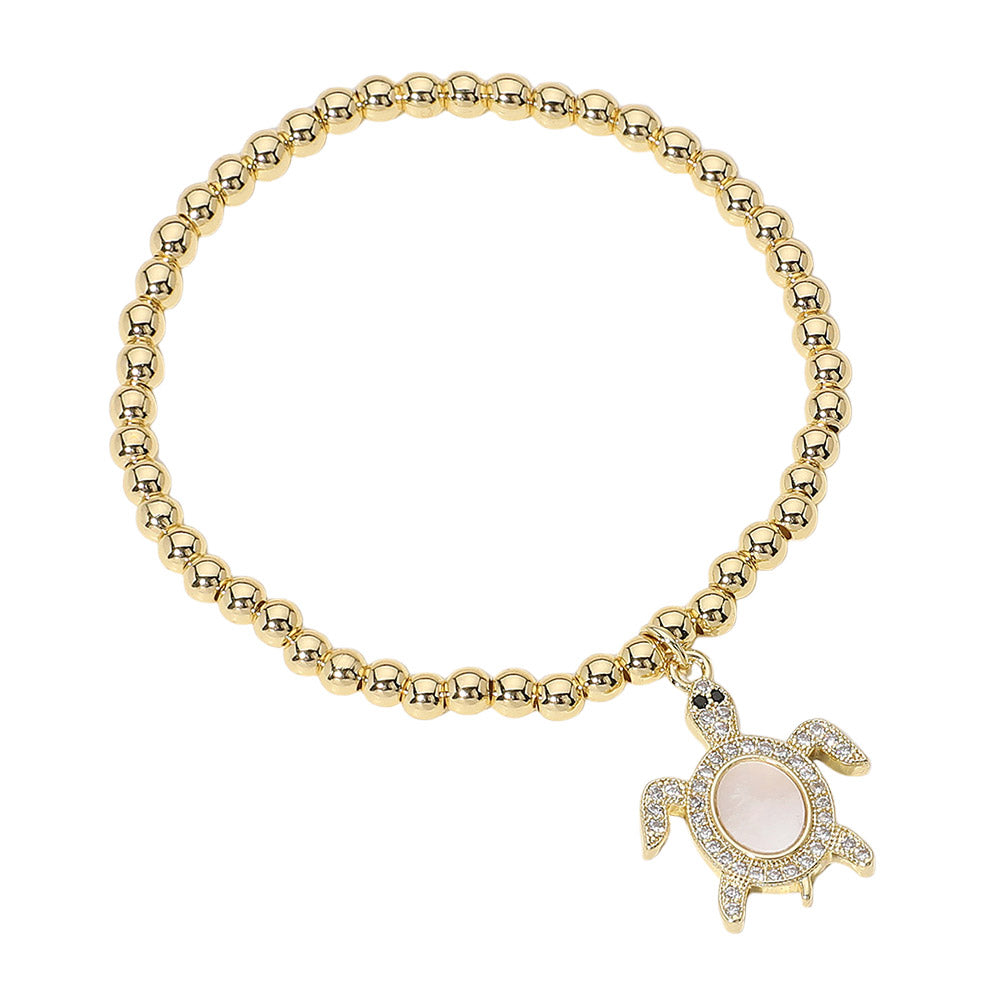 Gold Stainless Steel Ball Mother of Pearl Sea Turtle Charm Beaded Stretch Bracelet combines a beautiful mother of pearl sea turtle charm with durable stainless steel and effortless stretch design. Show your love for the sea and add a touch of elegance to any outfit. Expertly crafted for lasting beauty. 