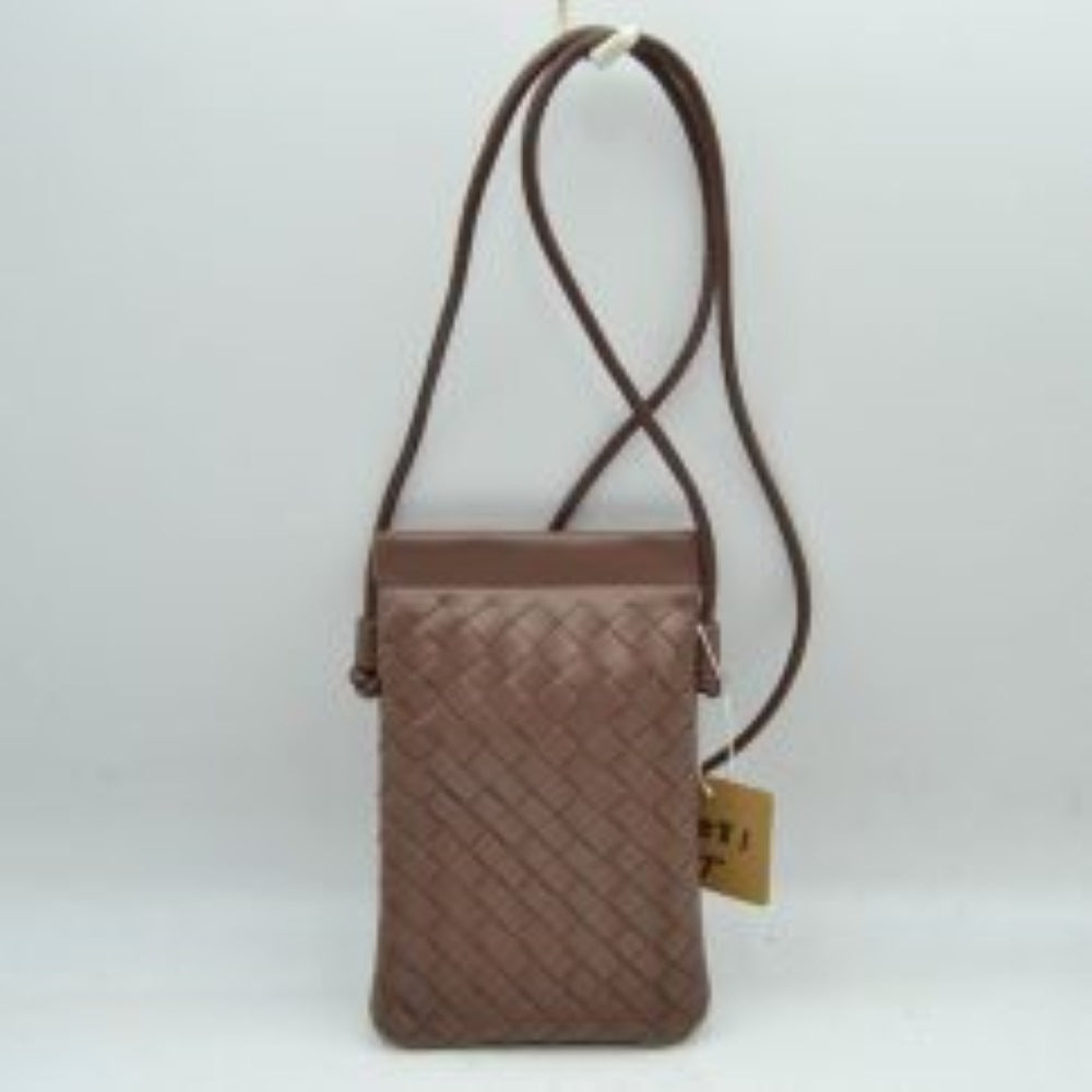 Steel This compact vertical crossbody bag is designed for everyday functionality with a distinct woven textured pattern across its body. It features a slim, continuous cord strap attached securely to the sides with visible knot details for comfortable carrying. A clean horizontal opening at the top allows effortless access to the main storage compartment