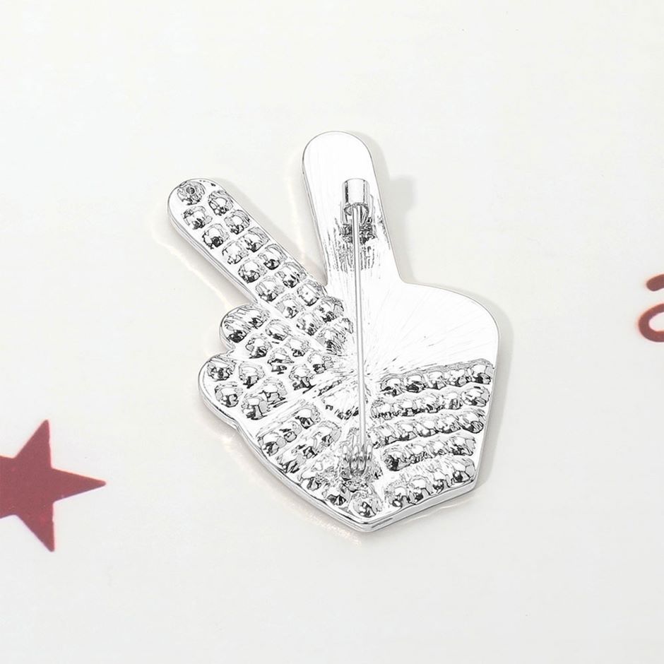 Rhodium Celebrate unity and patriotism with this Stone Paved American USA Flag Peace Hand Sign Pin Brooch, featuring a striking peace gesture filled with the iconic stars and stripes and accented by sparkling stones. A meaningful and stylish accessory, it’s perfect for adding a bold statement of freedom, harmony, and American pride to jackets, bags, or hats.