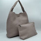 Stone This chic, slouchy shoulder bag features an intricate basket-weave design in a creamy off-white tone, offering a highly textured and relaxed silhouette for stylish everyday use. It is crafted with an integrated wide, woven top handle that extends seamlessly from the main body panels for comfortable over-the-shoulder carrying. The spacious open-top main compartment provides effortless access to your items and comes complete with a matching
