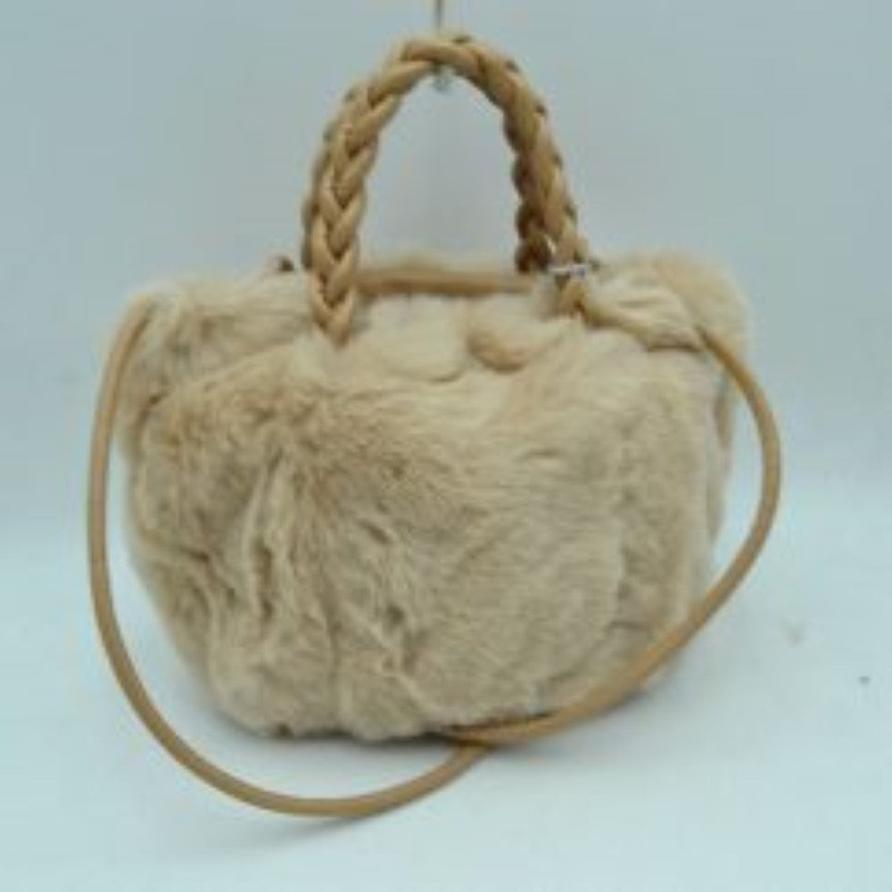 Stone This soft everyday bucket-style handbag features a densely textured, plush exterior that offers a cozy aesthetic for daily use. Designed with a structured yet flexible silhouette, it features dual braided top handles for comfortable hand carrying alongside a slender, long shoulder strap that provides hands-free convenience. The top opening reveals a spacious central storage compartment ideal for organizing essential items