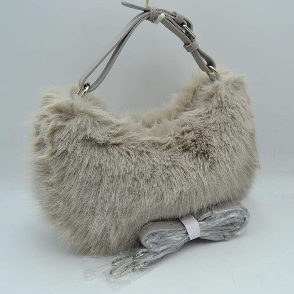 Stone This unique everyday handbag showcases a soft, high-pile plush exterior that brings a cozy, textured aesthetic to your accessory collection. Designed in a relaxed hobo silhouette, it features a central main storage compartment to keep your daily items easily accessible. For versatile carrying options, the bag is equipped with an adjustable top handle attached to metallic rings, alongside an additional detachable shoulder strap.