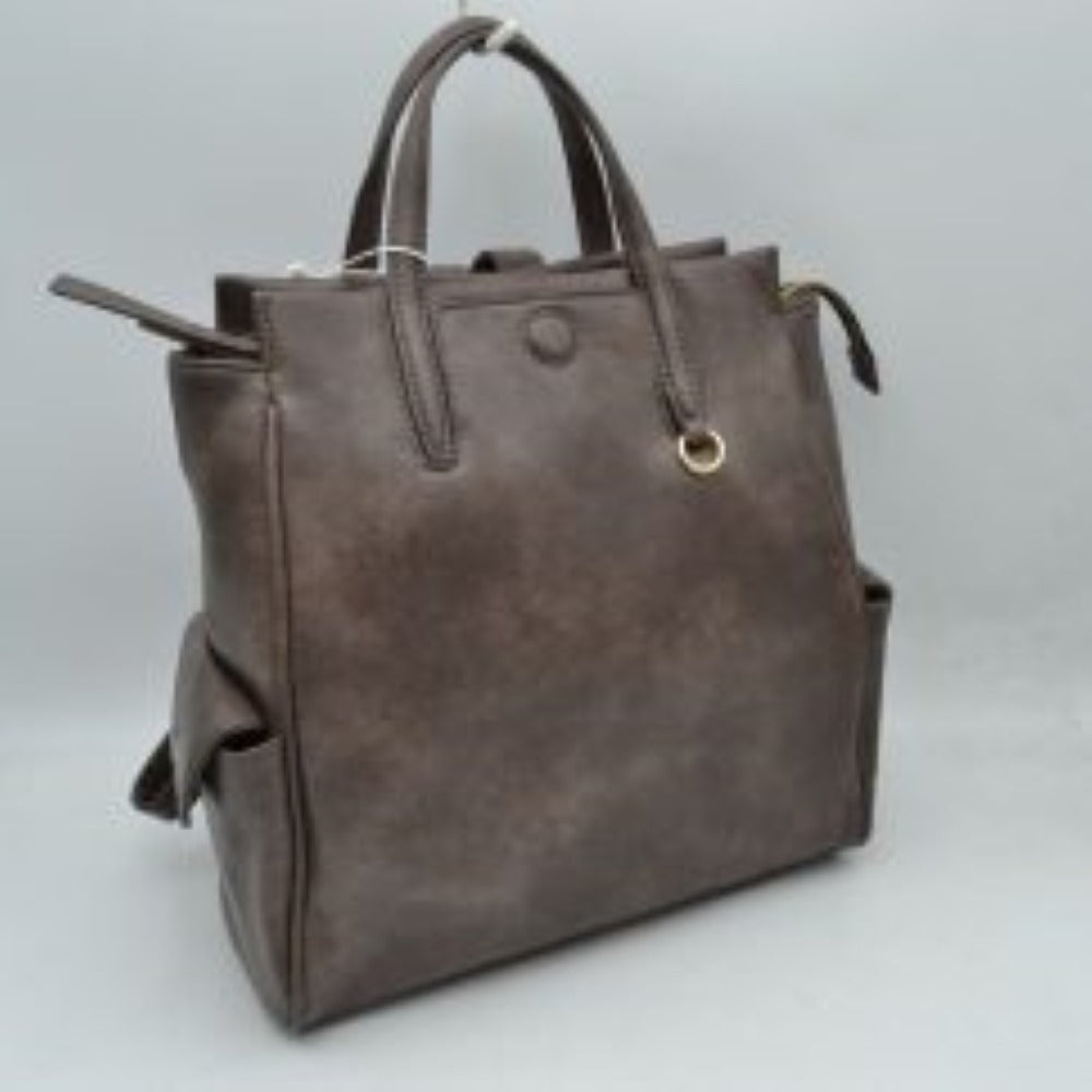 Stone This everyday tote bag features structured dual top handles for hand or forearm carrying, paired with a secure top zipper closure that extends slightly beyond the edge. The front panel is detailed with a covered central button accent and a small metallic ring attached near the base of one handle. Designed for convenient organization, the exterior includes functional side pockets with buttoned flaps, while the main compartment offers ample storage space for daily essentials.