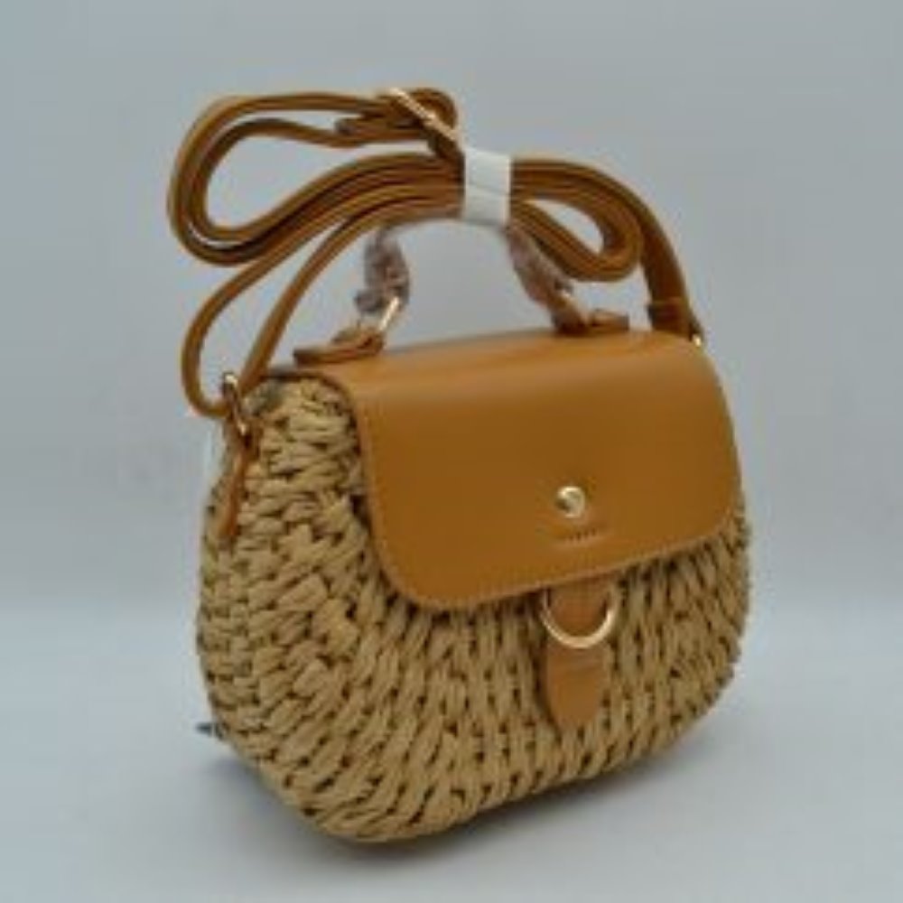 Tan Make a sophisticated statement wherever you go with this elegantly structured woven tote bag. Featuring a distinctive diagonal checkerboard weave pattern, this handbag brings a touch of modern luxury and rich texture to any wardrobe. The front is beautifully accented with a unique metallic centerpiece detail threaded through polished grommets, adding a contemporary twist to a classic silhouette. Designed for maximum versatility