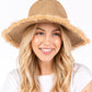 Taupe Frayed Band and Trip Straw Sun Hat combines style and practicality. The frayed band adds a touch of texture, while the trip straw material provides superior sun protection. Perfect for a day at the beach or a stroll in the park, this hat will keep you both fashionable and protected.
