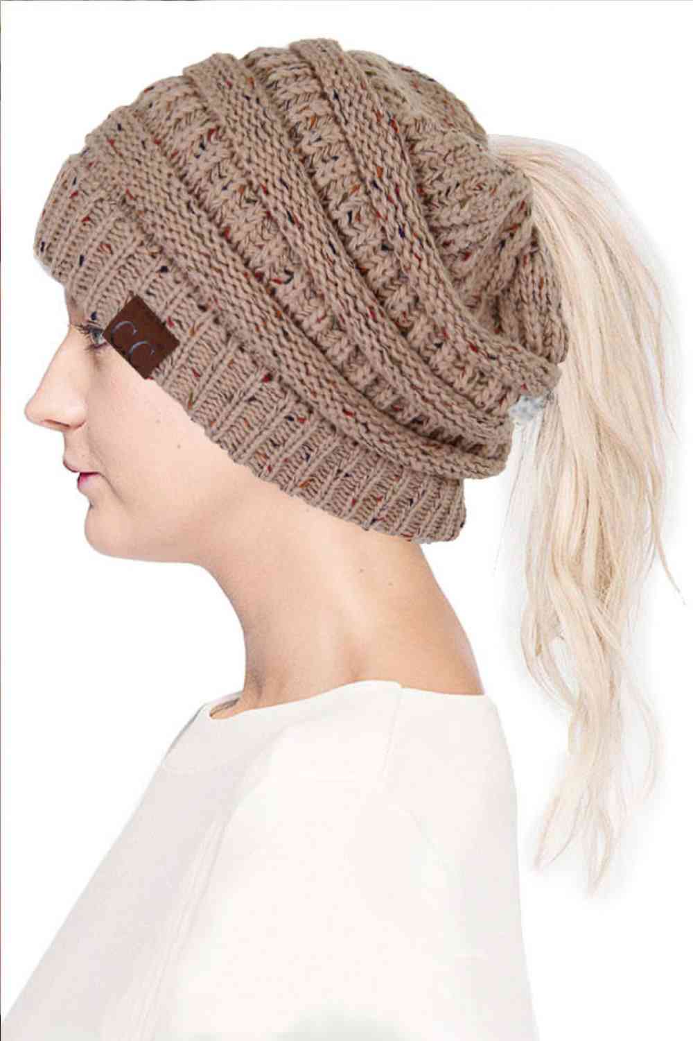 Taupe The C.C Confetti Ponytail Messy Bun Beanie features a soft knit design with subtle confetti flecks for a fun, playful look. Designed with a convenient opening for ponytails or messy buns, it keeps you warm while allowing you to style your hair comfortably.