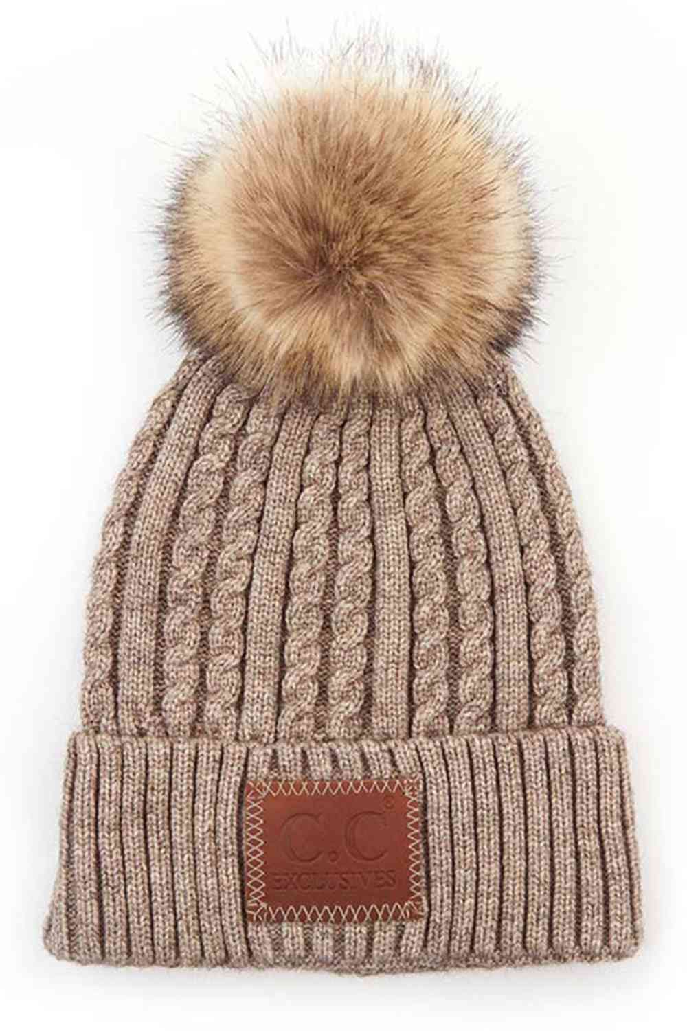 Taupe Stay warm and stylish with the C.C Double Braided Beanie, featuring a cozy pom-pom and iconic C.C leather patch. Crafted from a durable blend of 75% acrylic and 25% nylon, this beanie offers comfort and longevity through every season.