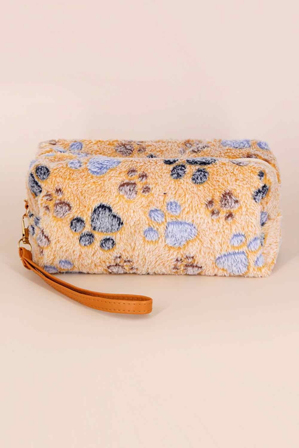 Adorable faux fur wristlet featuring playful paw print details. This compact pouch is perfect for carrying essentials like cards, cash, and small accessories on the go. Soft, plush texture with a convenient wrist strap for easy carrying. An ideal gift for animal lovers and a fun addition to any collection.