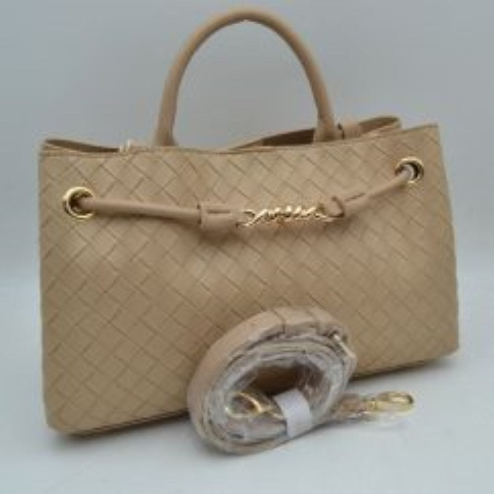 Taue Make a sophisticated statement wherever you go with this elegantly structured woven tote bag. Featuring a distinctive diagonal checkerboard weave pattern, this handbag brings a touch of modern luxury and rich texture to any wardrobe. The front is beautifully accented with a unique metallic centerpiece detail threaded through polished grommets, adding a contemporary twist to a classic silhouette. Designed for maximum versatility, it features comfortable dual top handles alongside a wrapped