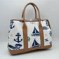 Taupe Set sail with this nautical-inspired canvas tote. Featuring a crisp backdrop decorated with a classic print of anchors, sailboats, ship wheels, and ocean waves, this bag is the perfect accessory for coastal getaways or adding maritime flair to your daily ensemble. Framed with structured textured trim, it balances casual resort style with sharp, everyday functionality.